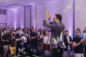 Palestrante interagindo com o público durante uma apresentação presencial